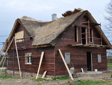 Dom z drewna pokryty strzechą 